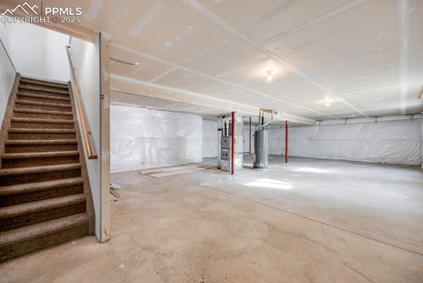 Unfinished basement with heating unit and water heater