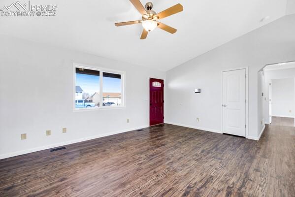 Unfurnished living room with lofted ceiling, dark wood-style floors, a ceiling fan, and arched walkways
