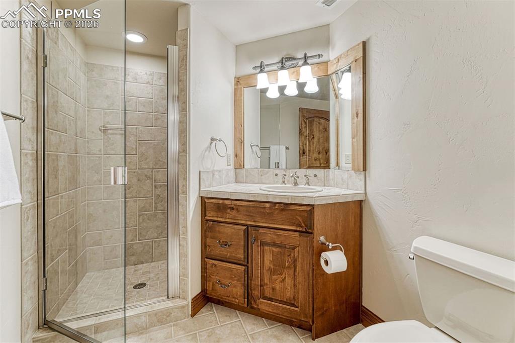 All bathrooms feature elegant all-tile finishes in neutral tones.