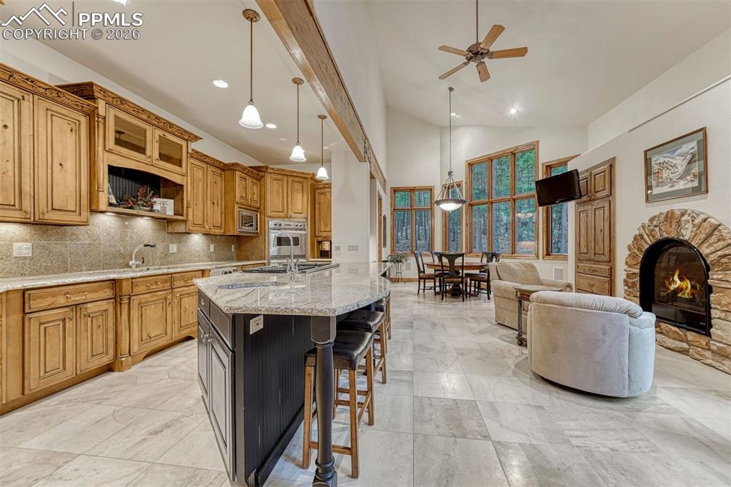 Spacious kitchen with slab granite counters and distressed maple cabinetry.