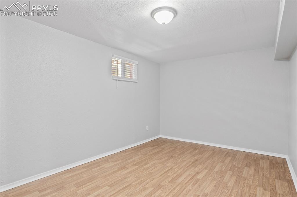 Empty room with light wood-style flooring and a textured ceiling