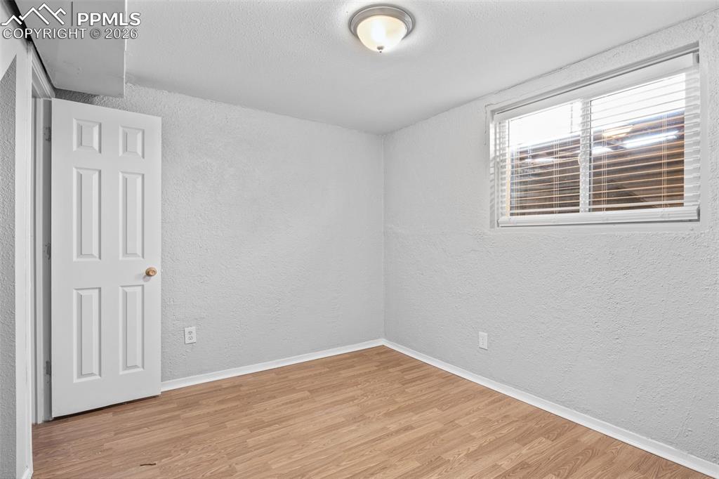 Bedroom featuring a textured wall and light wood-type flooring