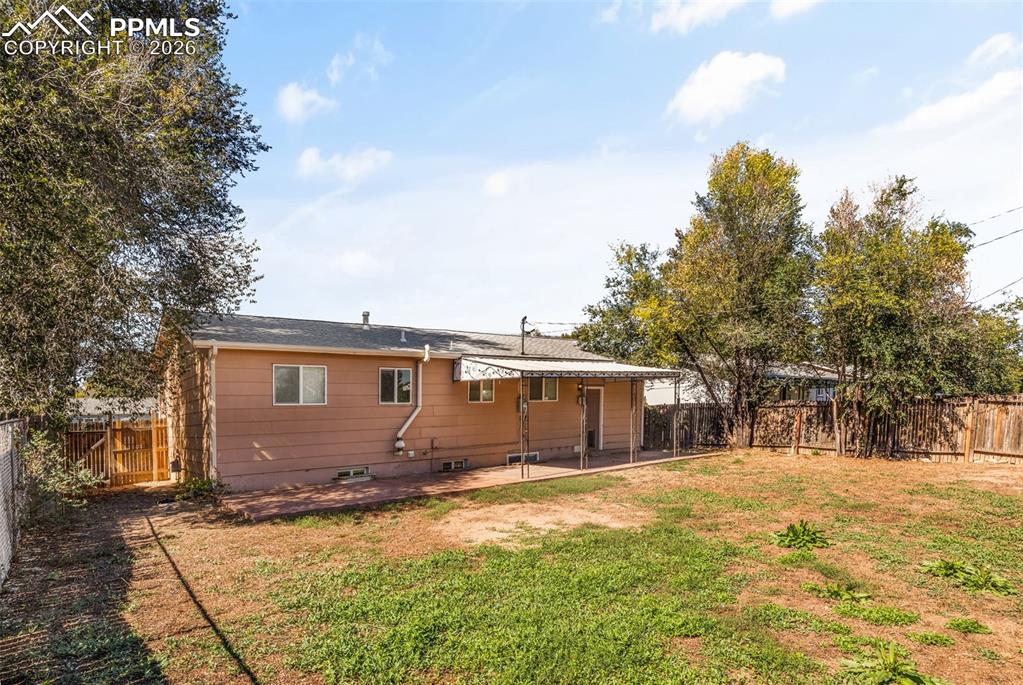 Rear view of house with a patio and a fenced backyard
