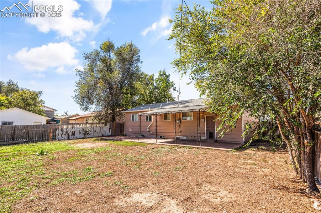 Rear view of house featuring a patio and a fenced backyard