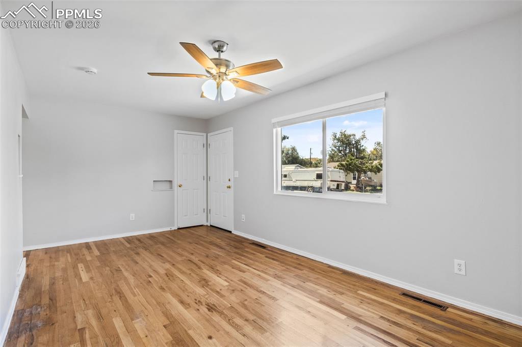 Living room with light wood-type flooring and a ceiling fan