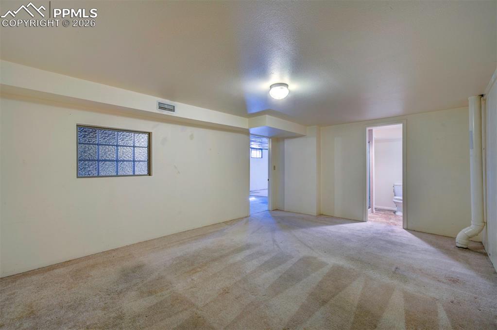 Another view of non-conforming bedroom, with view to 3/4 bath and into open basement area