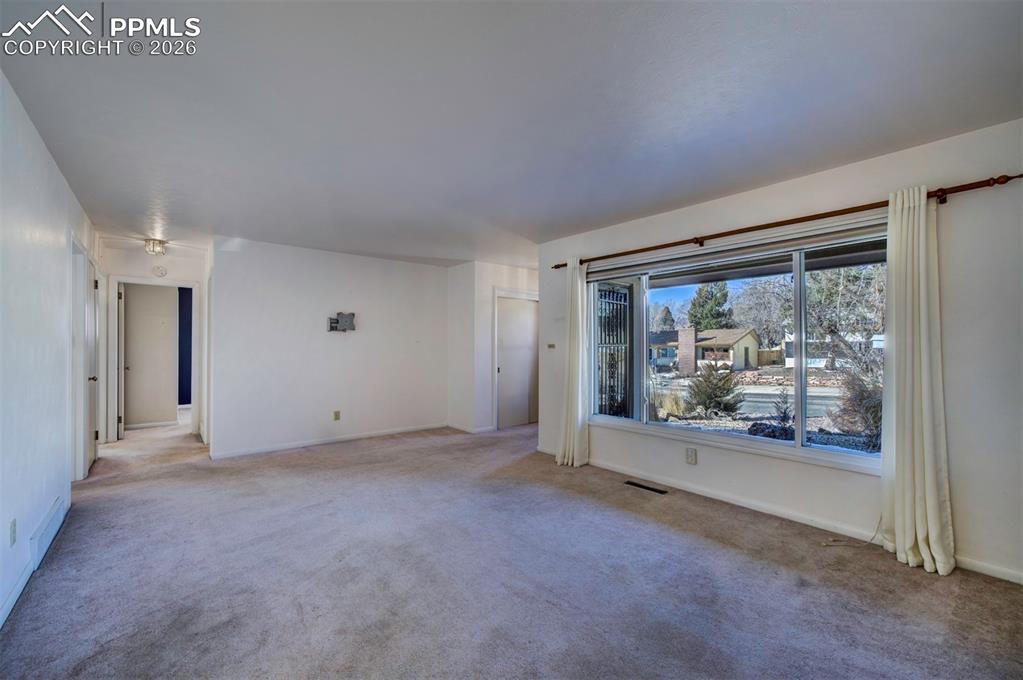 Living room with large picture window; looking down hallway to bedrooms