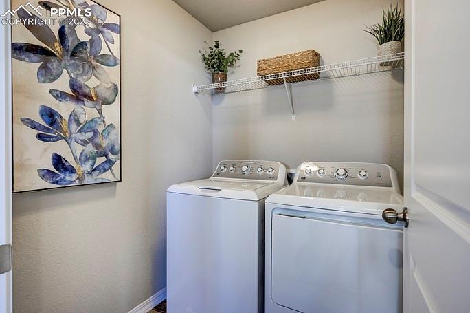 Laundry area featuring washer and dryer and baseboards
