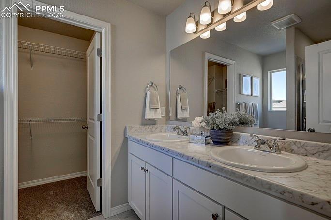 Full bath with a walk in closet and double vanity