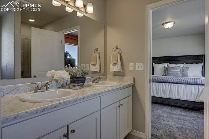 Bathroom with double vanity, ensuite bathroom, and a shower stall