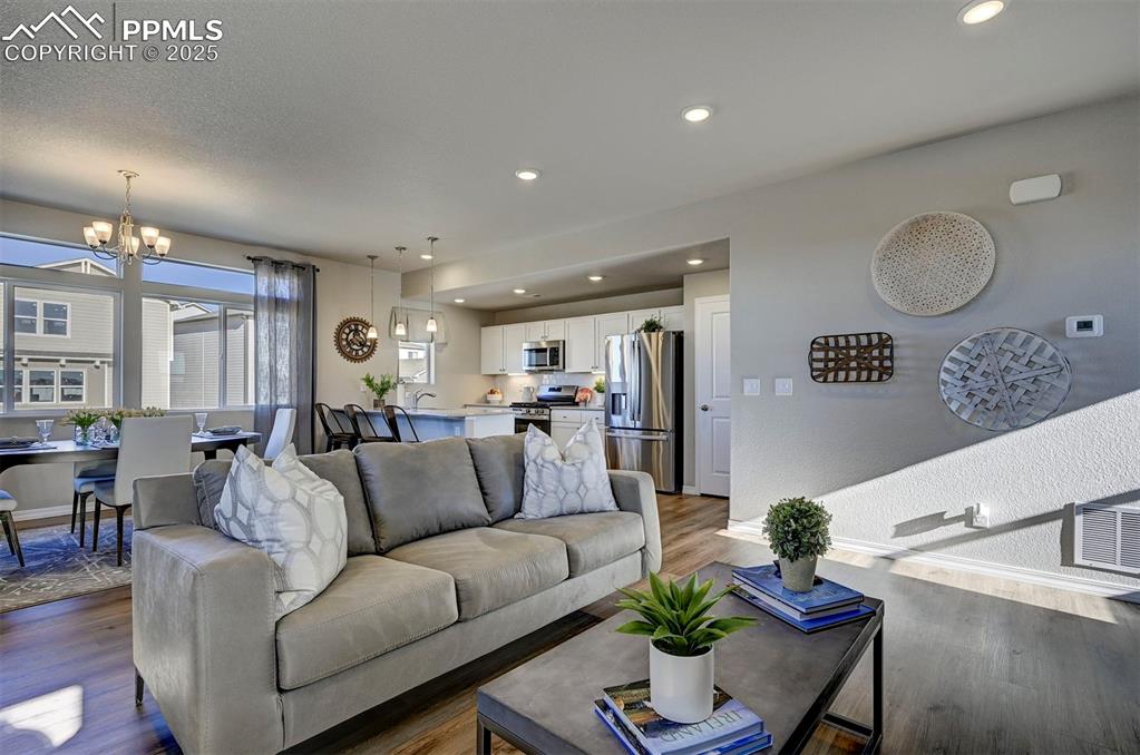 Living room featuring recessed lighting, light wood-style flooring, and a chandelier