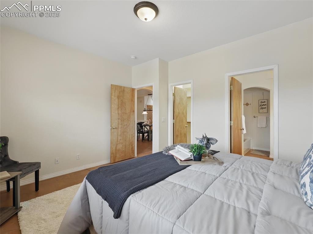 Bedroom featuring ensuite bathroom and arched walkways