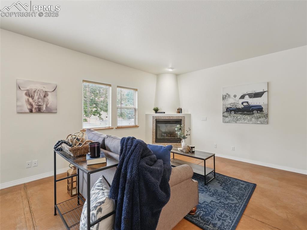 Living area featuring baseboards and a tile fireplace