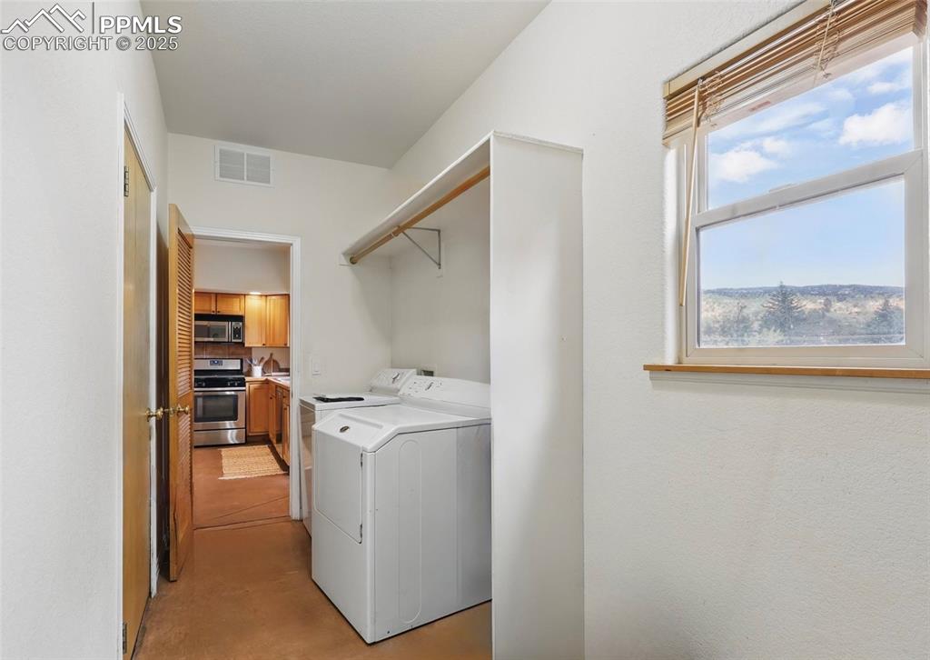 Laundry room featuring concrete floors and washer and dryer