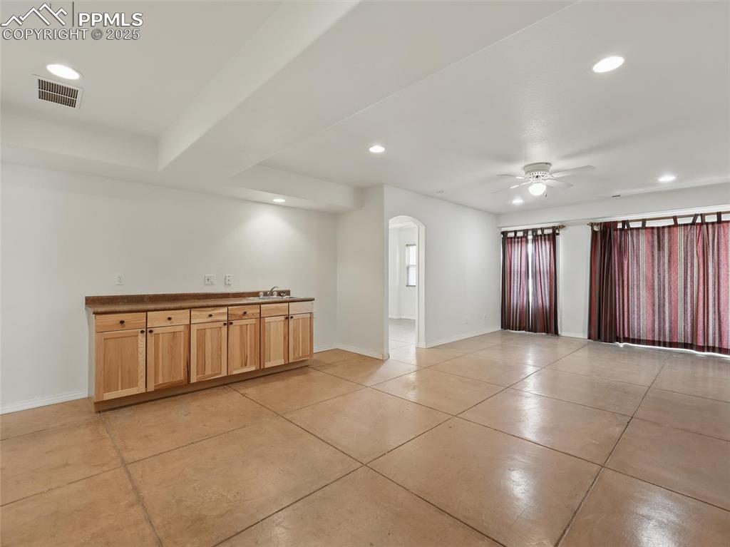 Unfurnished room with recessed lighting, arched walkways, a ceiling fan, and light tile patterned flooring