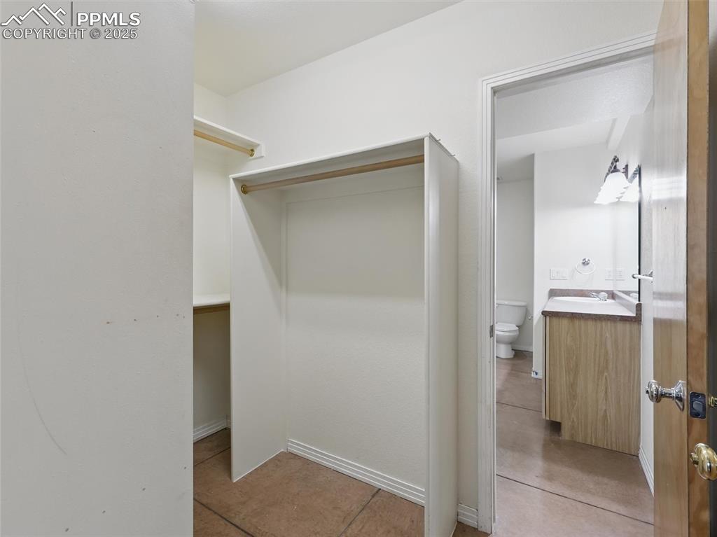 Walk in closet with light tile patterned floors