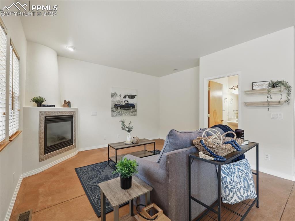 Living area with a tiled fireplace and baseboards