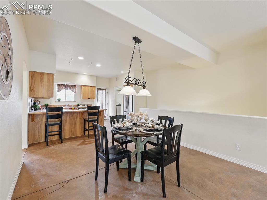 Dining room with finished concrete floors and recessed lighting
