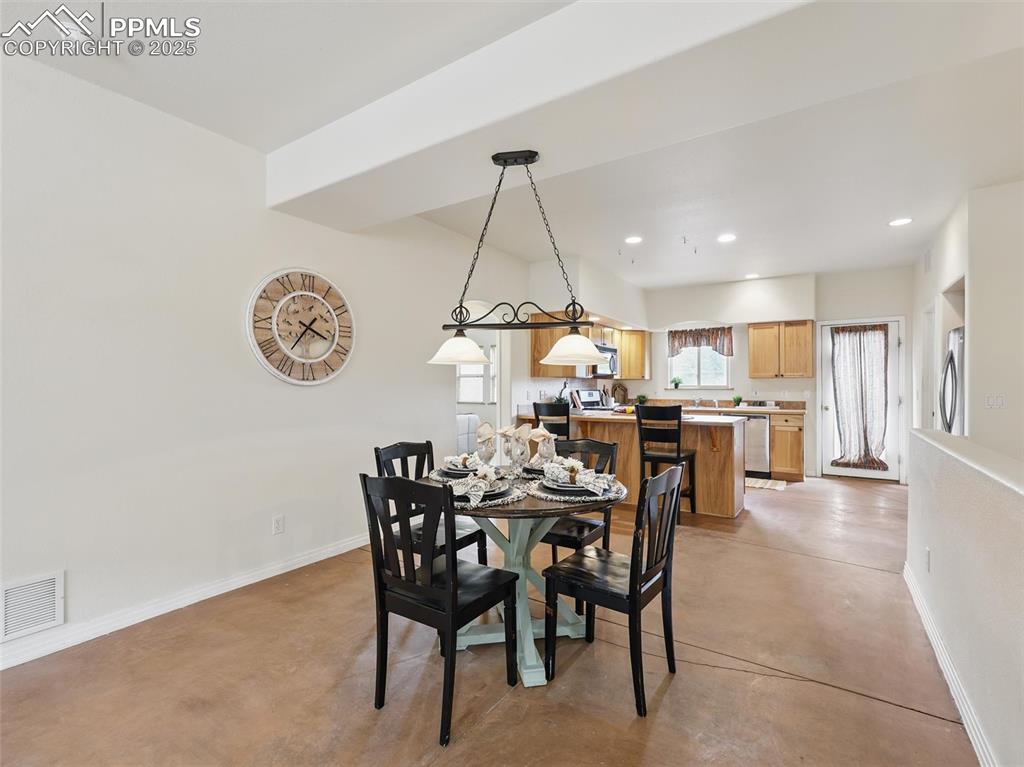 Dining space featuring finished concrete flooring and recessed lighting