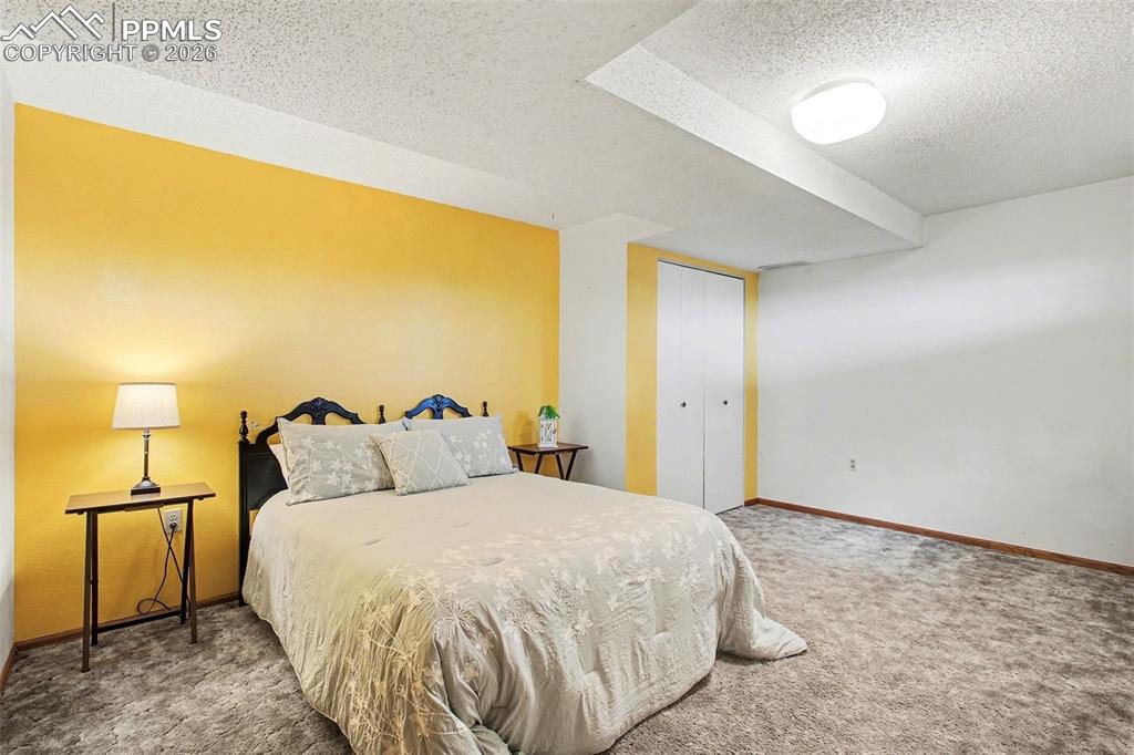 Bedroom featuring a textured ceiling, carpet flooring, and a closet