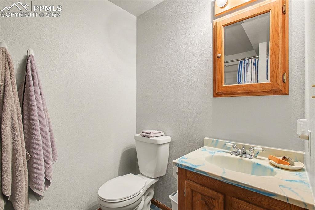 Bathroom featuring a textured wall and vanity