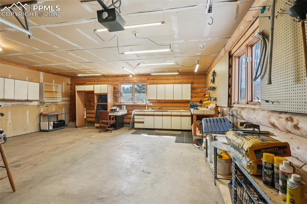 Garage featuring a workshop area and a garage door opener