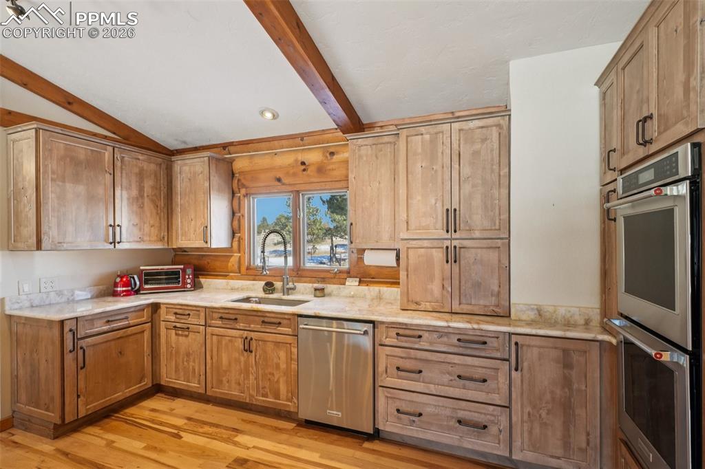 Kitchen featuring stainless steel appliances,, vaulted ceiling, hickory floors and alder cabinets