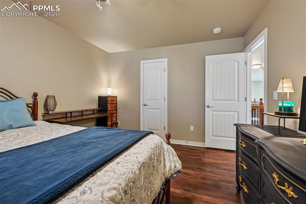 Bedroom with dark wood-type flooring and baseboards