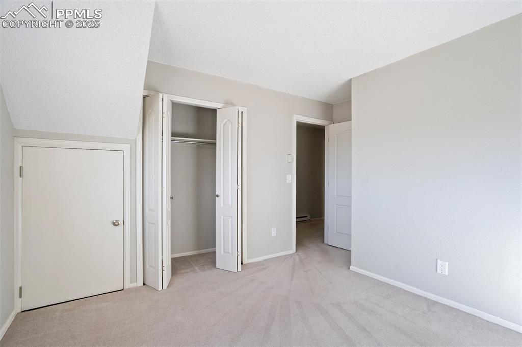 Unfurnished bedroom featuring light colored carpet and a closet