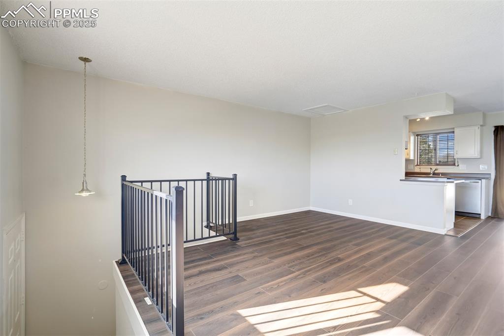 Spare room featuring baseboards and dark wood-style flooring