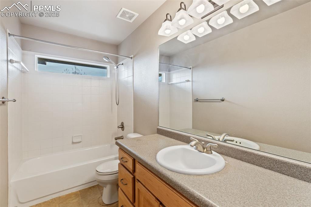 Upper level full bath offers a tiled tub/shower surround and tile flooring.