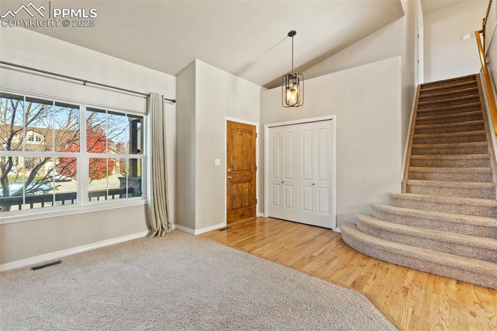 Welcome in! Oak hardwood floors grace the entry and flow into the open living area beyond this carpeted room.