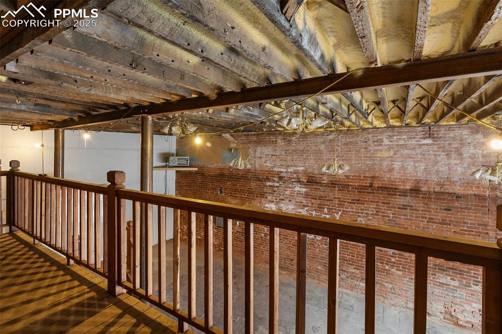 Unfinished 1899 storefront with large windows, high ceilings, and overhead loft area