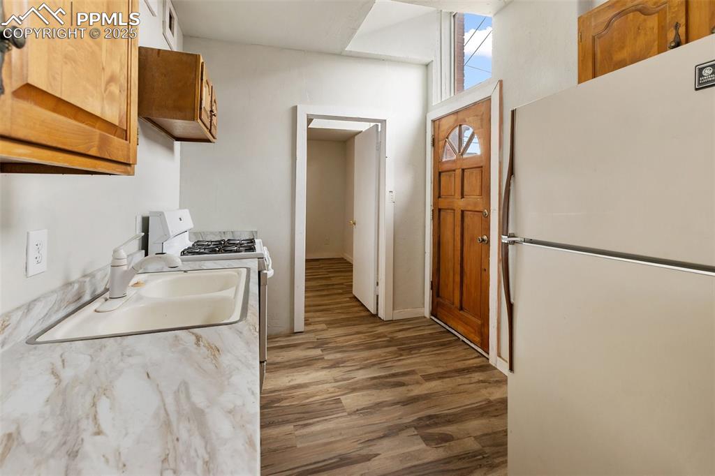 Kitchen featuring white appliances, light countertops, new laminate flooring