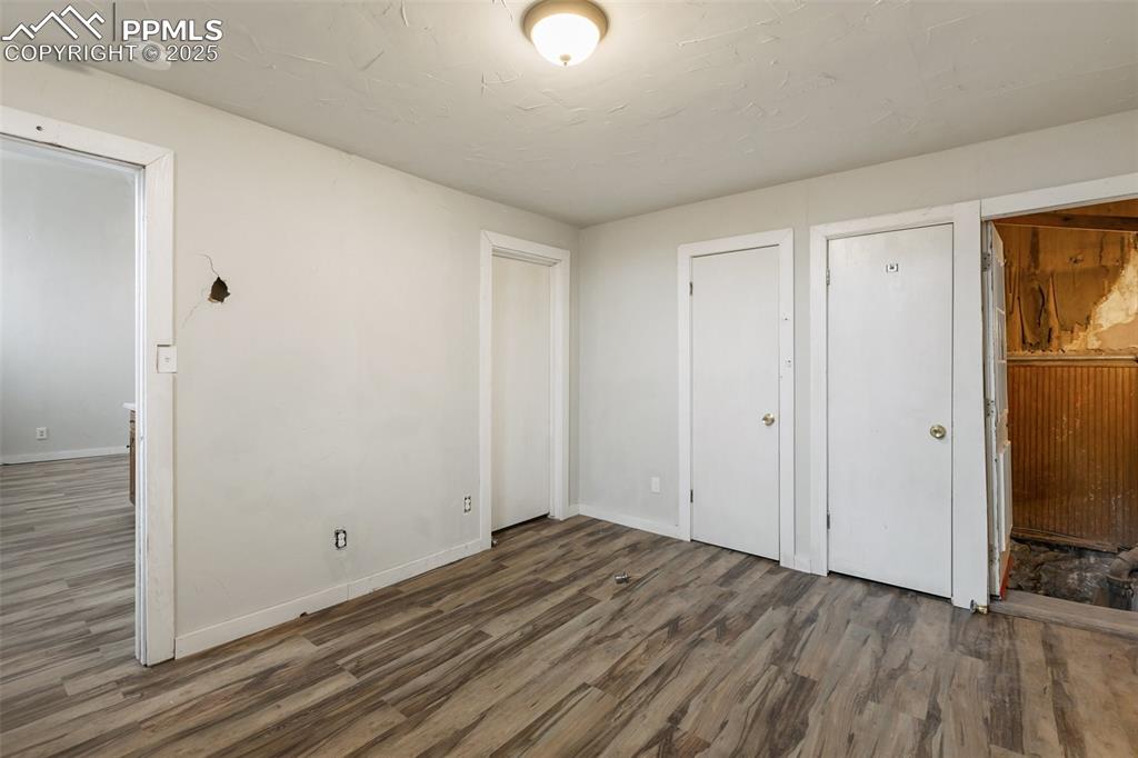Unfurnished bedroom with wood finished floors and baseboards