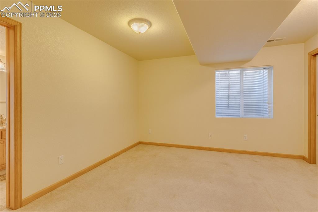 Empty room with light carpet and baseboards