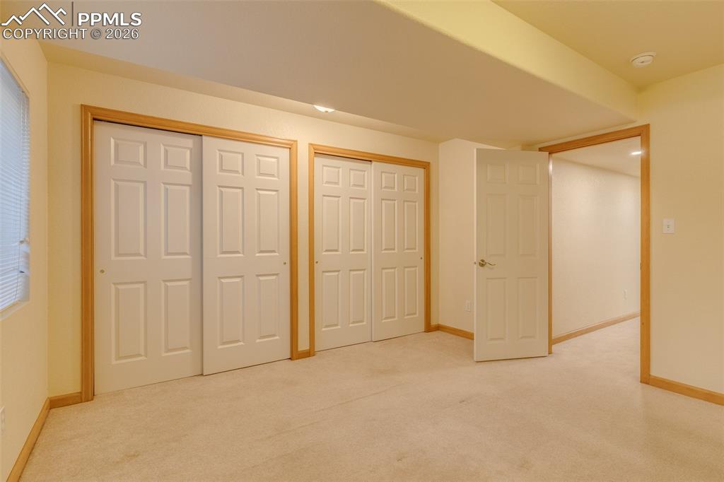 Unfurnished bedroom featuring two closets and light colored carpet
