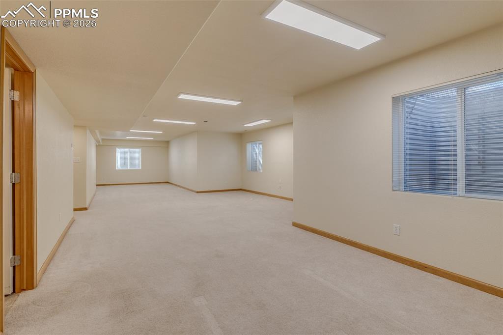 Unfurnished room with light carpet and baseboards