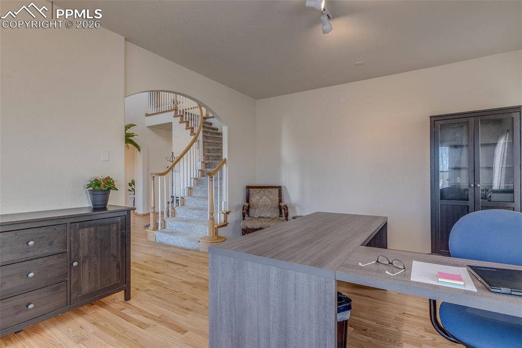 Office area featuring light wood-type flooring and arched walkways