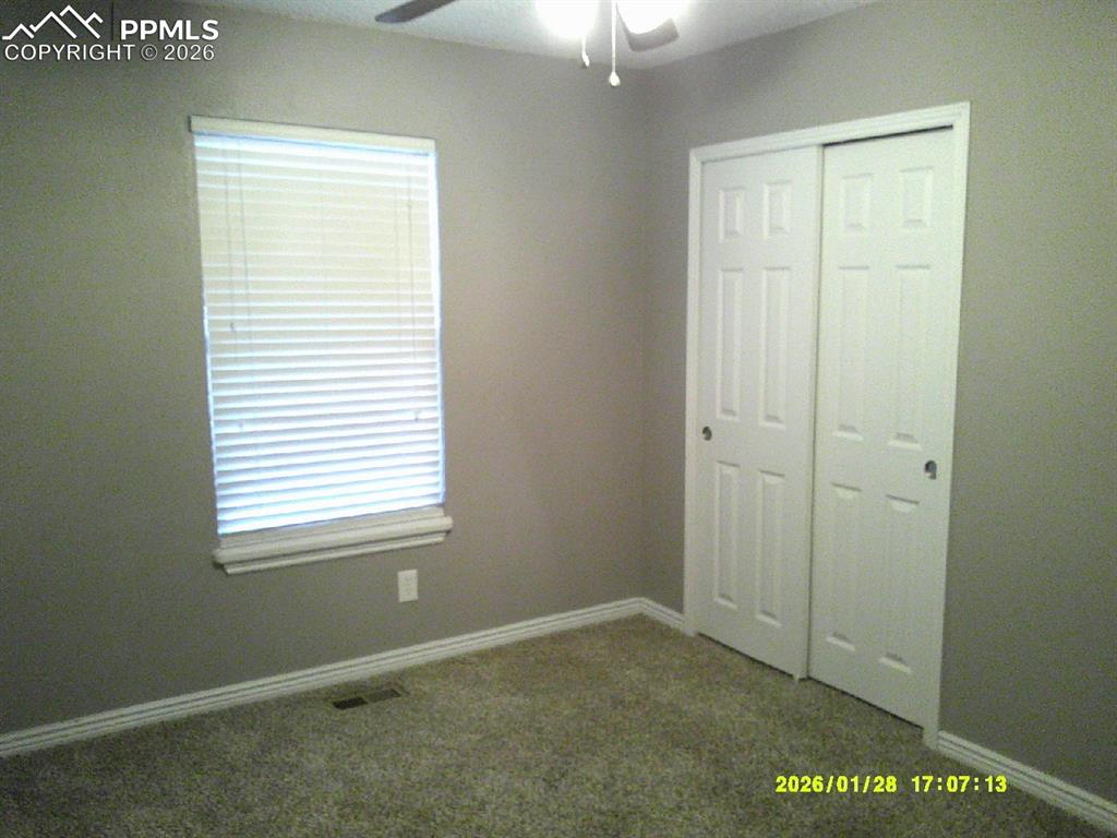 Unfurnished bedroom with carpet flooring, ceiling fan, and a closet