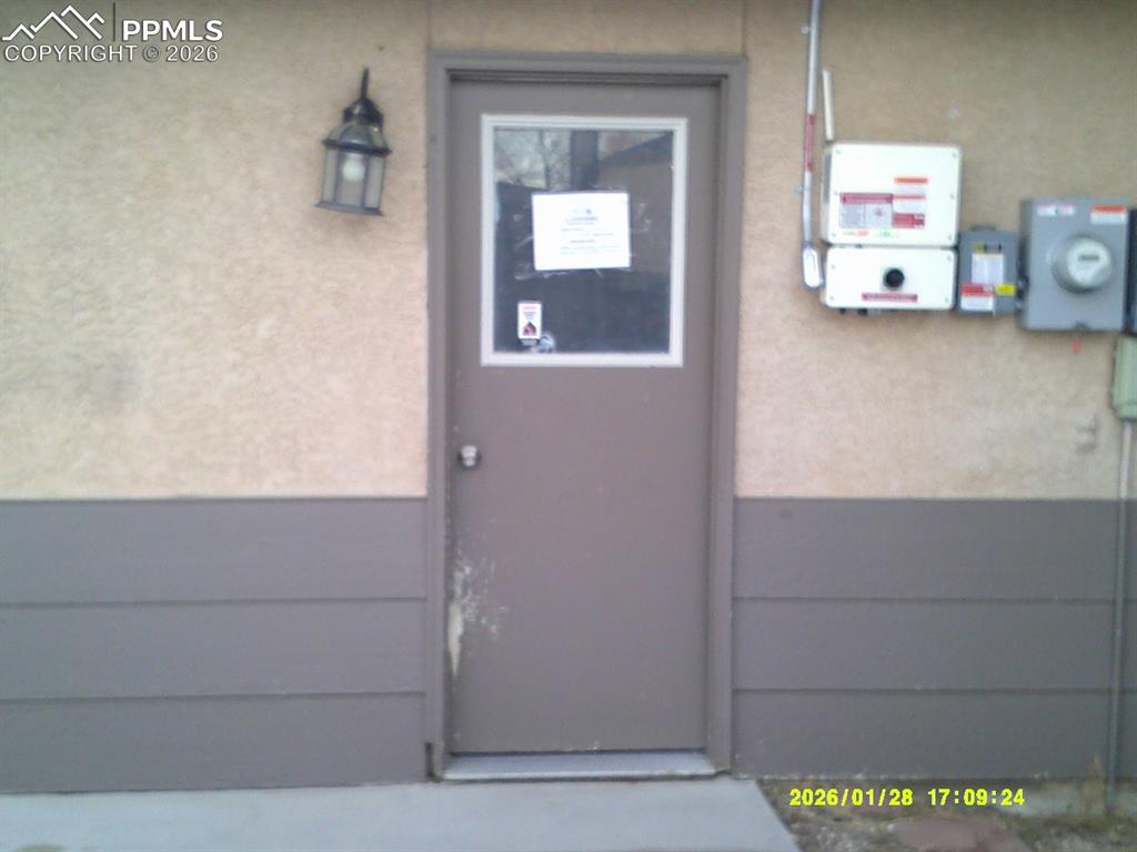 Doorway to property with stucco siding