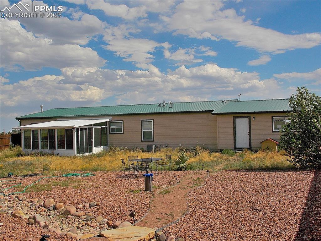 Back of house featuring a sunroom and door to garage