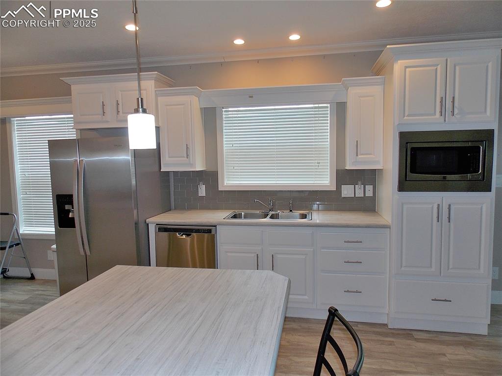 Kitchen with white cabinetry, tasteful backsplash, appliances with stainless steel finishes, and sink