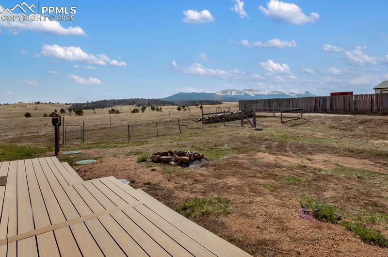 View of yard featuring a rural view, a mountain view, and fence