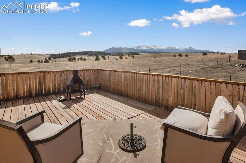 View of patio featuring a deck with mountain view and a rural view