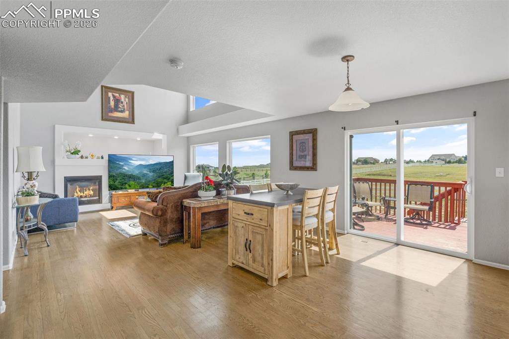 Dining space featuring a glass covered fireplace, light wood finished floors, and a textured ceiling