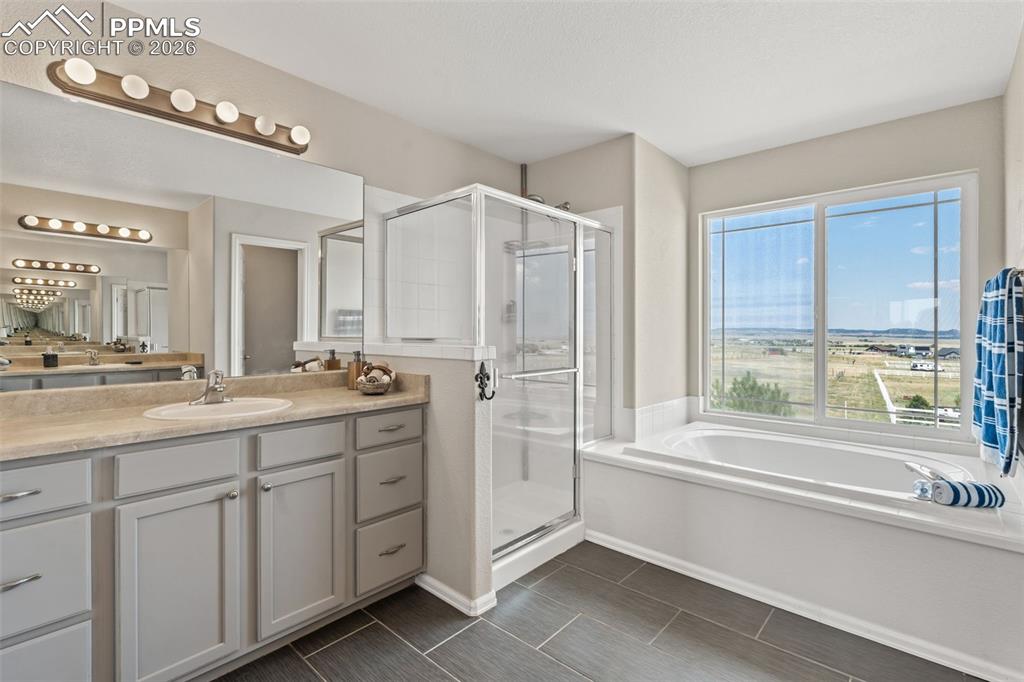 Full bath featuring a bath, a stall shower, and vanity