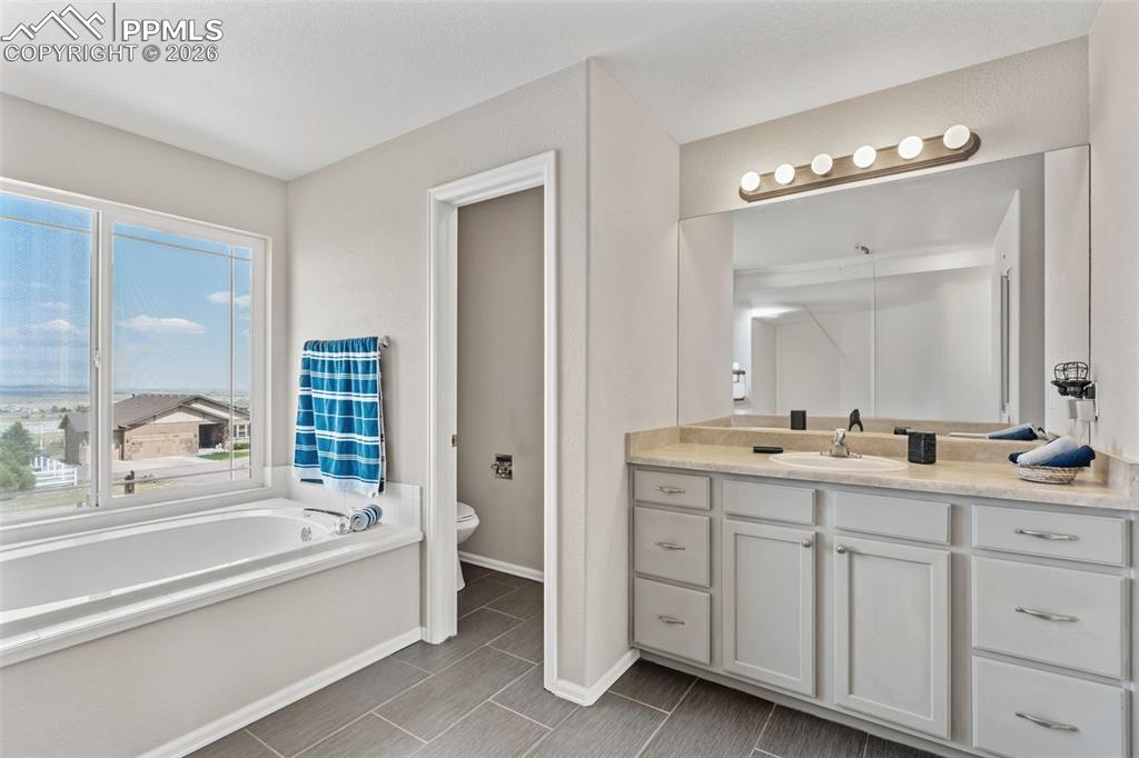 Full bathroom with vanity and a bath