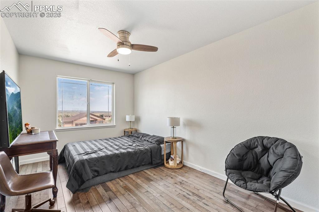 Bedroom featuring wood-type flooring and ceiling fan