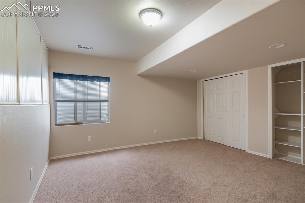 Basement-level bedroom featuring light carpet and a closet